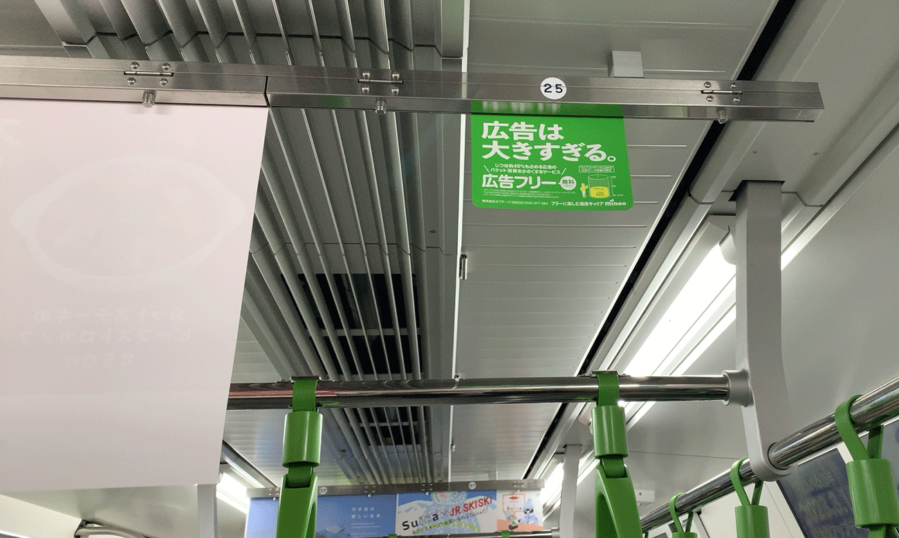 山手線内の中吊り広告。通常B3サイズポスターが掲出されるところに小さすぎるポスター