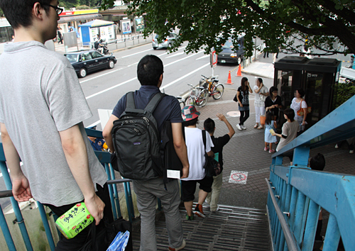 スタッフに先導されて歩道橋を渡る人々。さながら遠足です