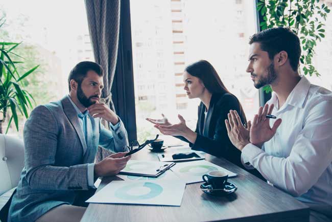 hree business partners in smart wear are discussing the finances of their company in a meeting in restaurant, all confused, arguing, denying, gesturing