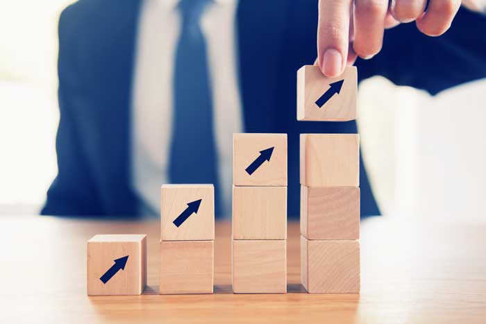 Business concept growth success process, Close up Businessman hand arranging wood cube with arrow stacking as step stair