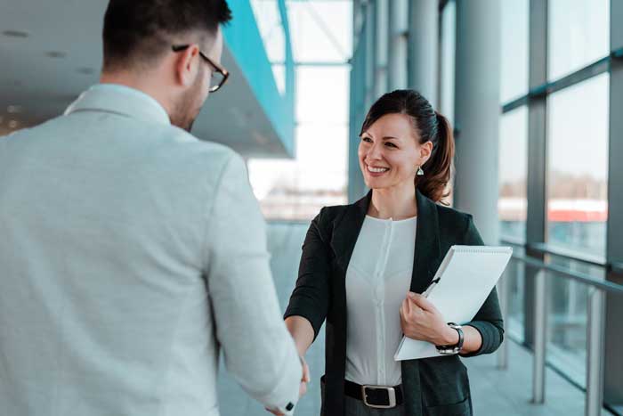 Business people handshake near the office building windows