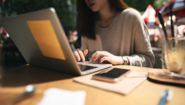 Business freelancer adult asian woman working with laptop computer at cafe