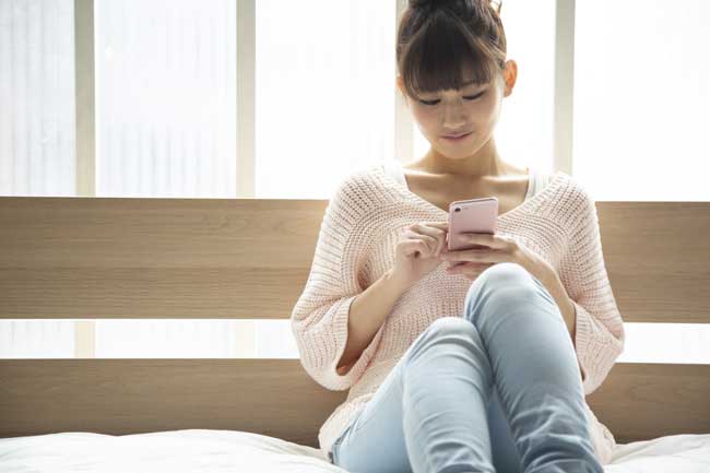 スマートフォンを見ている日本人女性