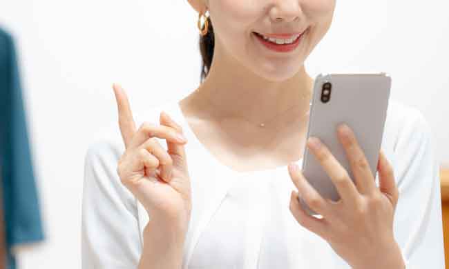 アパレルショップ スマホを使う女性