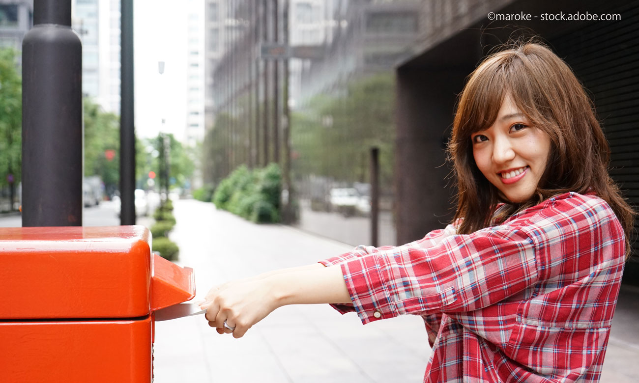 ポストに投函する女性