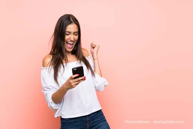Young woman with phone in victory position