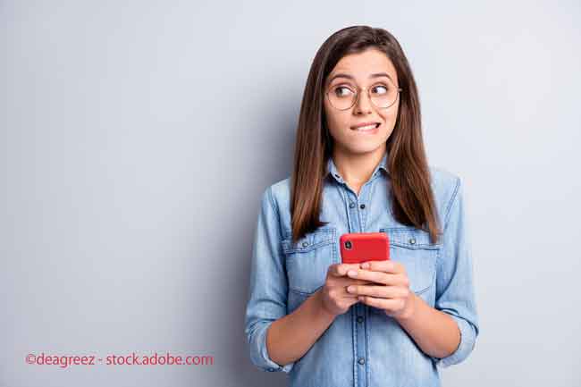 doubtful charming young woman look empty space hesitate hold phone