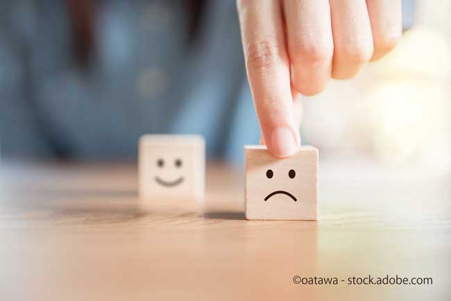 Close up customer hand choose sad face and blurred smiley face icon on wood cube