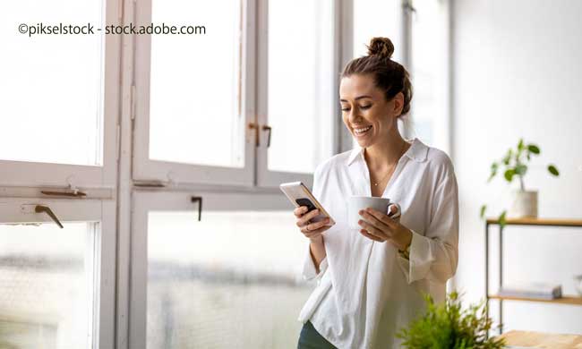 Creative business woman using smartphone in loft office
