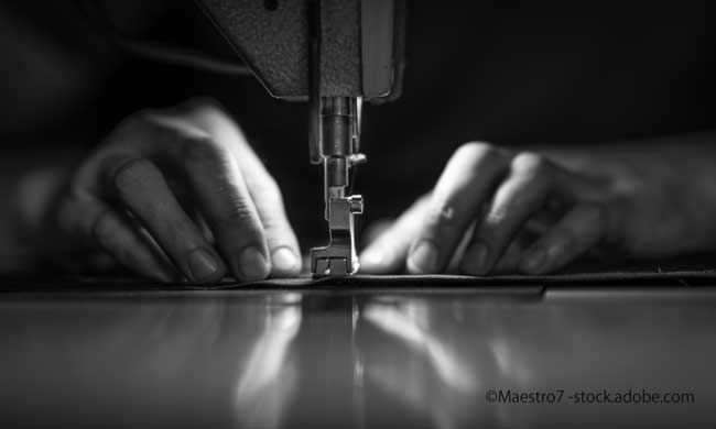 a man at work on a sewing machine. without a face