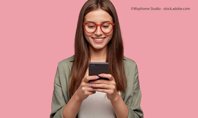 Satisfied lovely woman holds modern cell phone