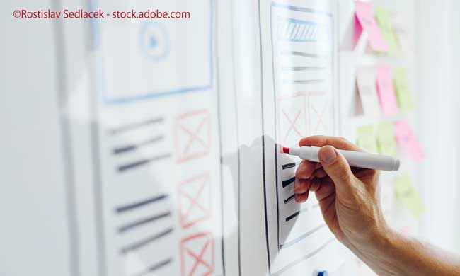 Close up of young web designer drawing website responsive layout on white board