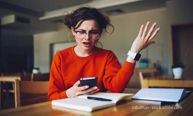 Angry attractive female feeling disappointed receiving with smartphone
