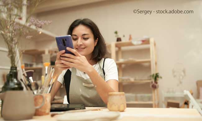Craftswoman with gadgets in pottery workshop