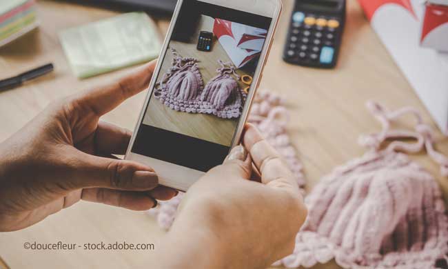 woman hand taking picture of her handmade product by smart phone for selling online