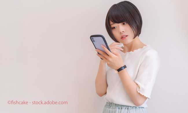 スマホを見て首をかしげる女性