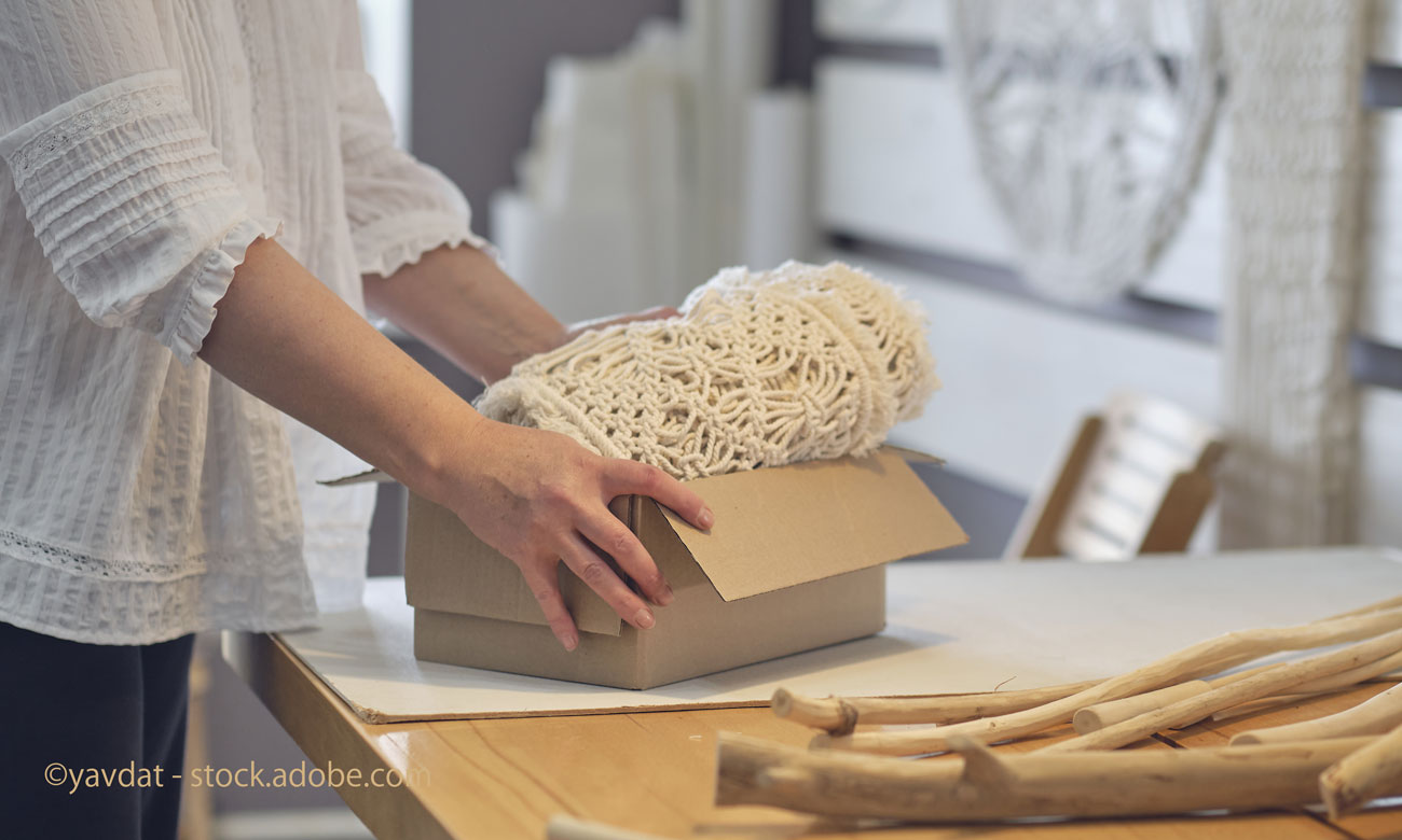 woman entrepreneur packs a handmade product in a cardboard box