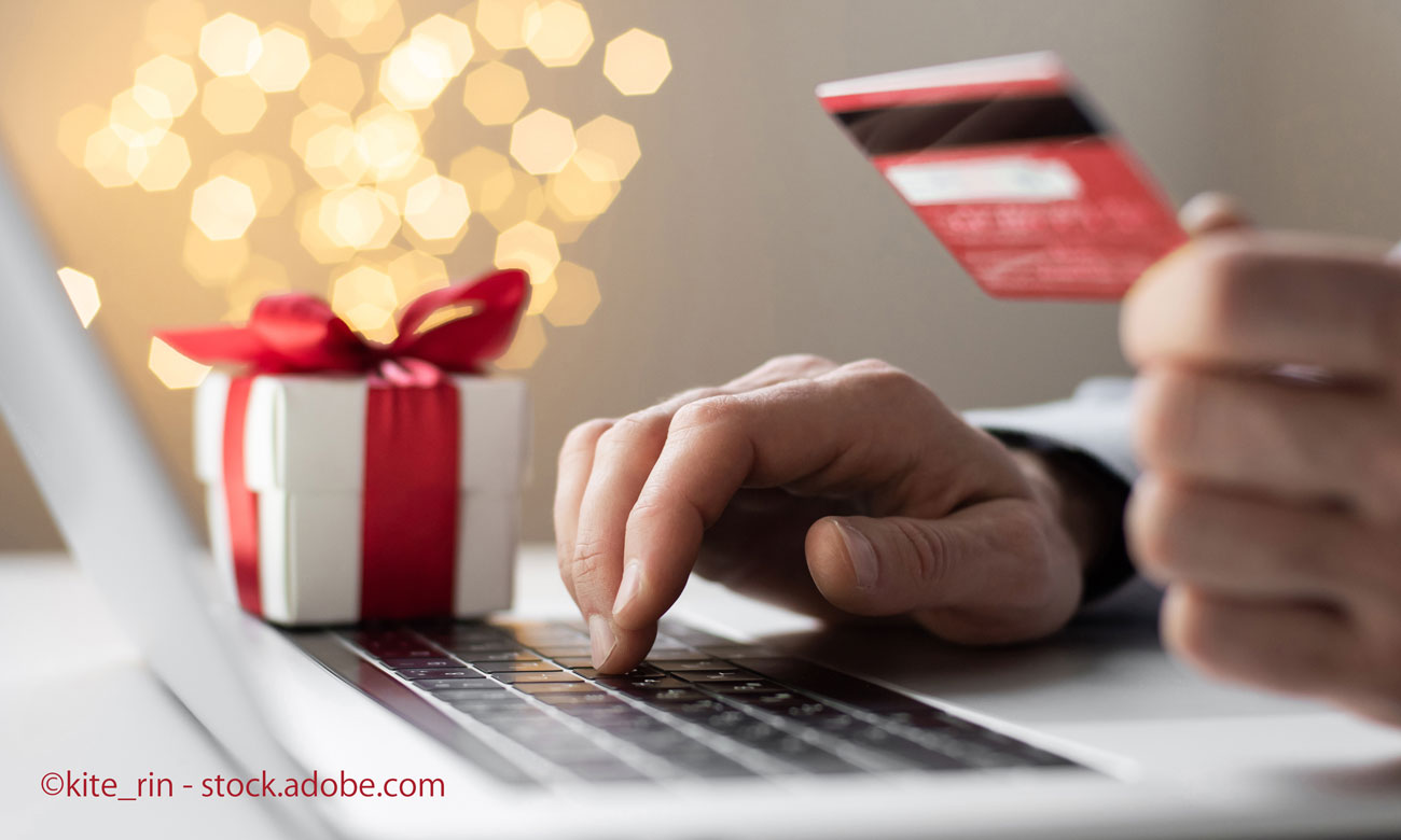 Man hand holding credit card and using laptop computer ordering Christmas gift