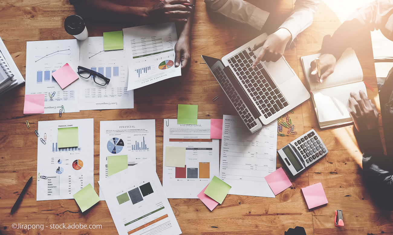 Business People Meeting using laptop computer,calculator,notebook,stock market chart paper for analysis Plans to improve quality next month