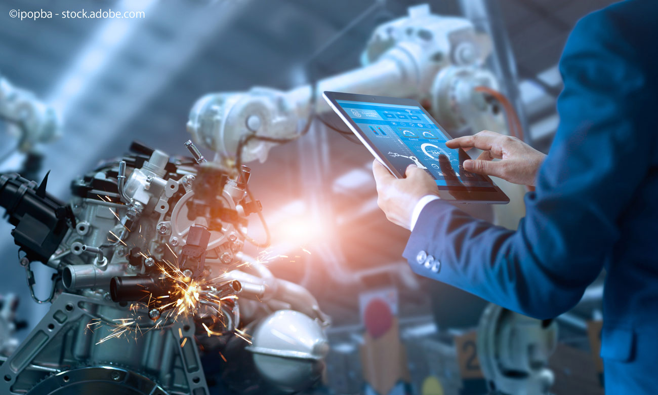 Engineer manager checking and controling automation robot arms machine in intelligent factory industrial on real time monitoring system software